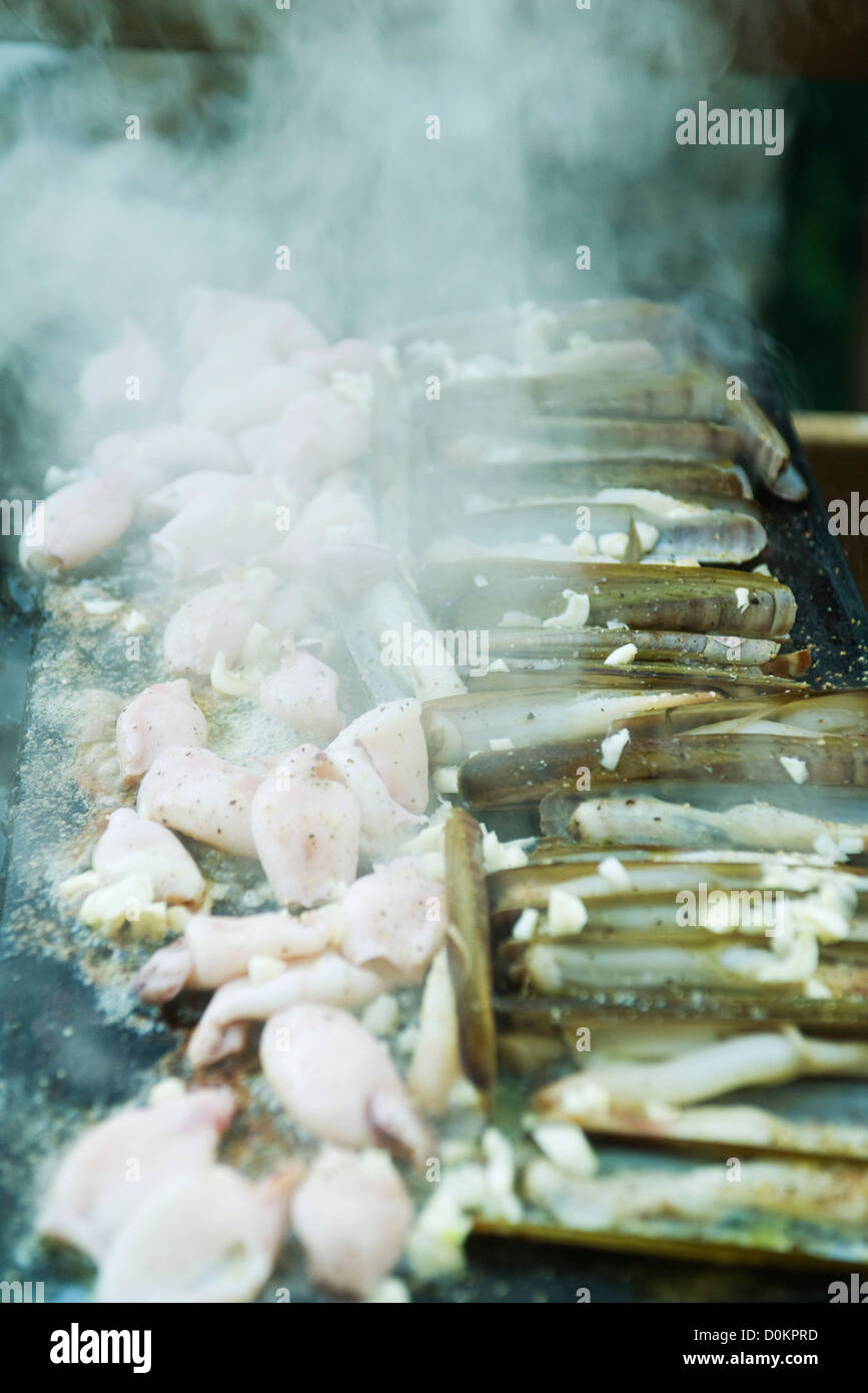 Gusci di rasoio e calamari grigliati barbecue, primo piano Foto Stock
