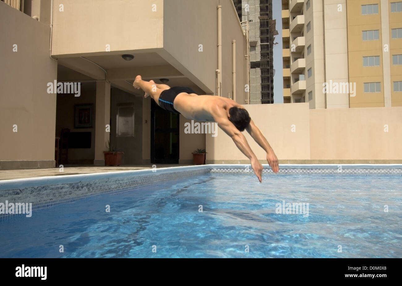 L'uomo nuotare nella piscina sul tetto dell'appartamento, Bahrain Foto Stock