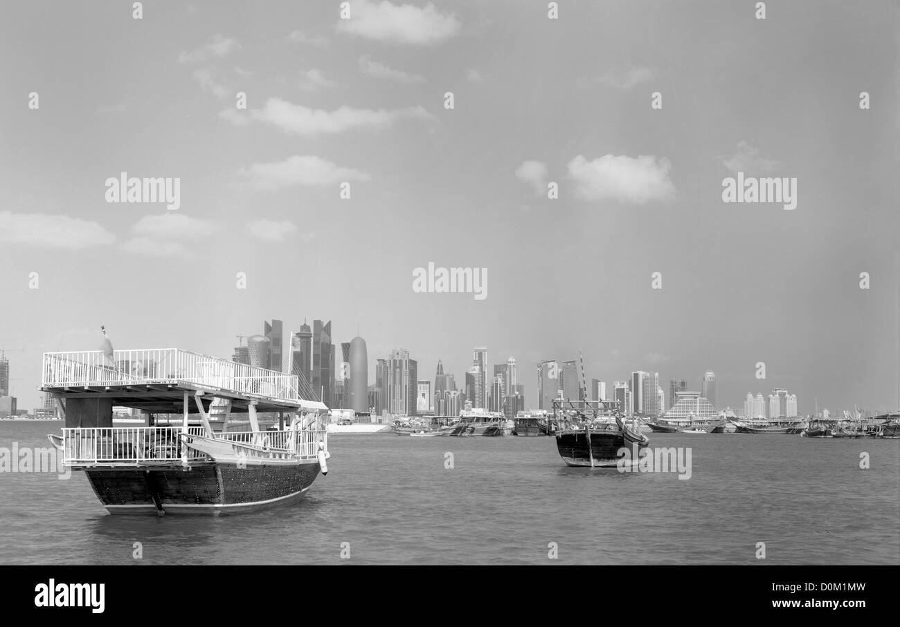 La baia di Doha, in Qatar, nel novembre 27, 2012, con due Dhow in primo piano e il quartiere commerciale skyline dietro. Foto Stock