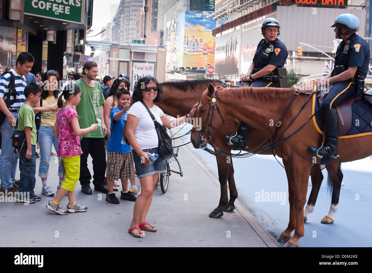Donna asiatica picchietti la polizia a cavallo,Times Square, NY Foto Stock