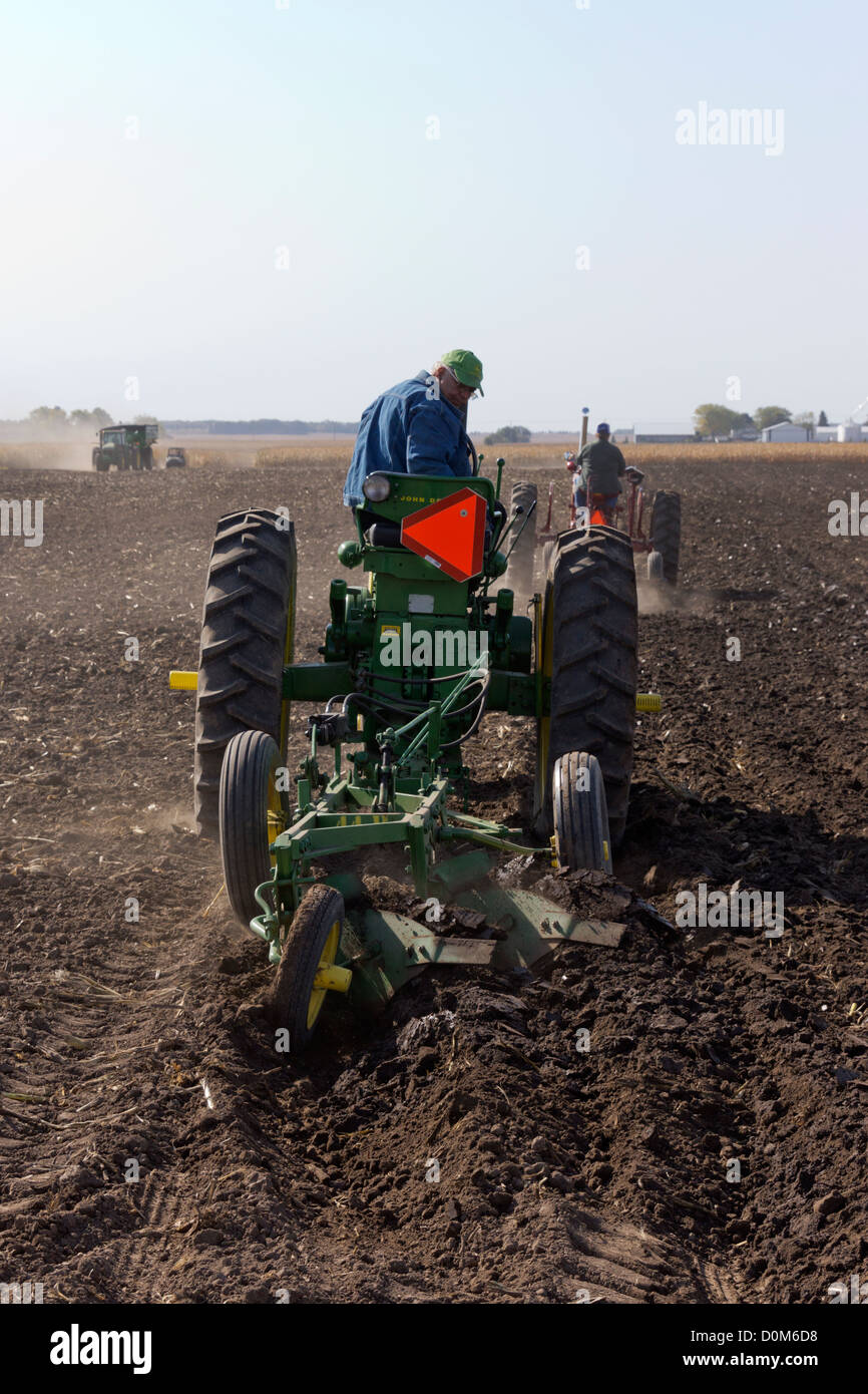 Trattore John Deere tirando un 2-Fondo aratro in un campo nei pressi di Hebron, Illinois durante un antico trattore dimostrazione. Foto Stock