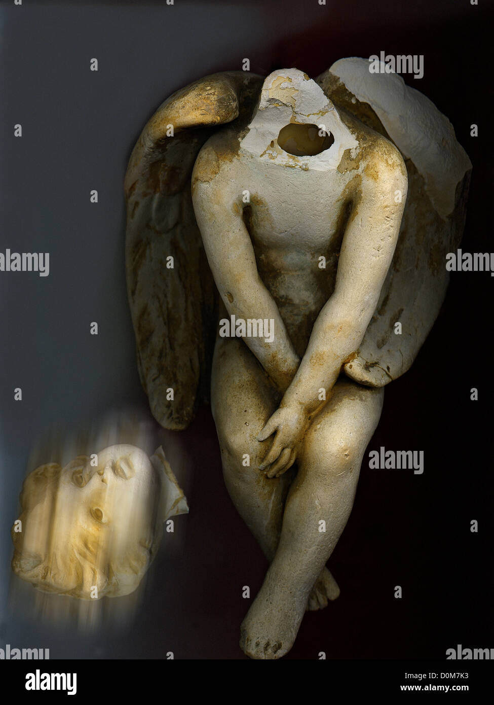 Rotto statua di giovani decapitati Angelo seduto accanto a perso la testa. Foto Stock