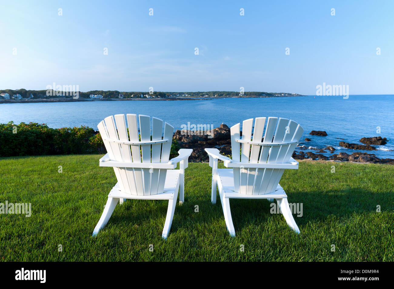 Due Bianche sedie Adirondack su un prato che si affaccia sull'Oceano Atlantico in York Beach, Maine, Stati Uniti d'America. Foto Stock
