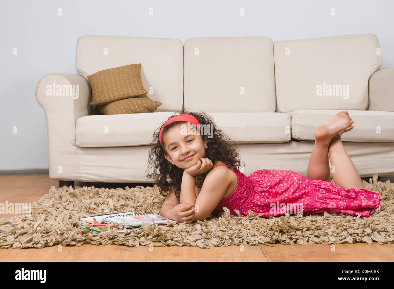 Ritratto di una ragazza distesa con un notebook e matite colorate Foto
