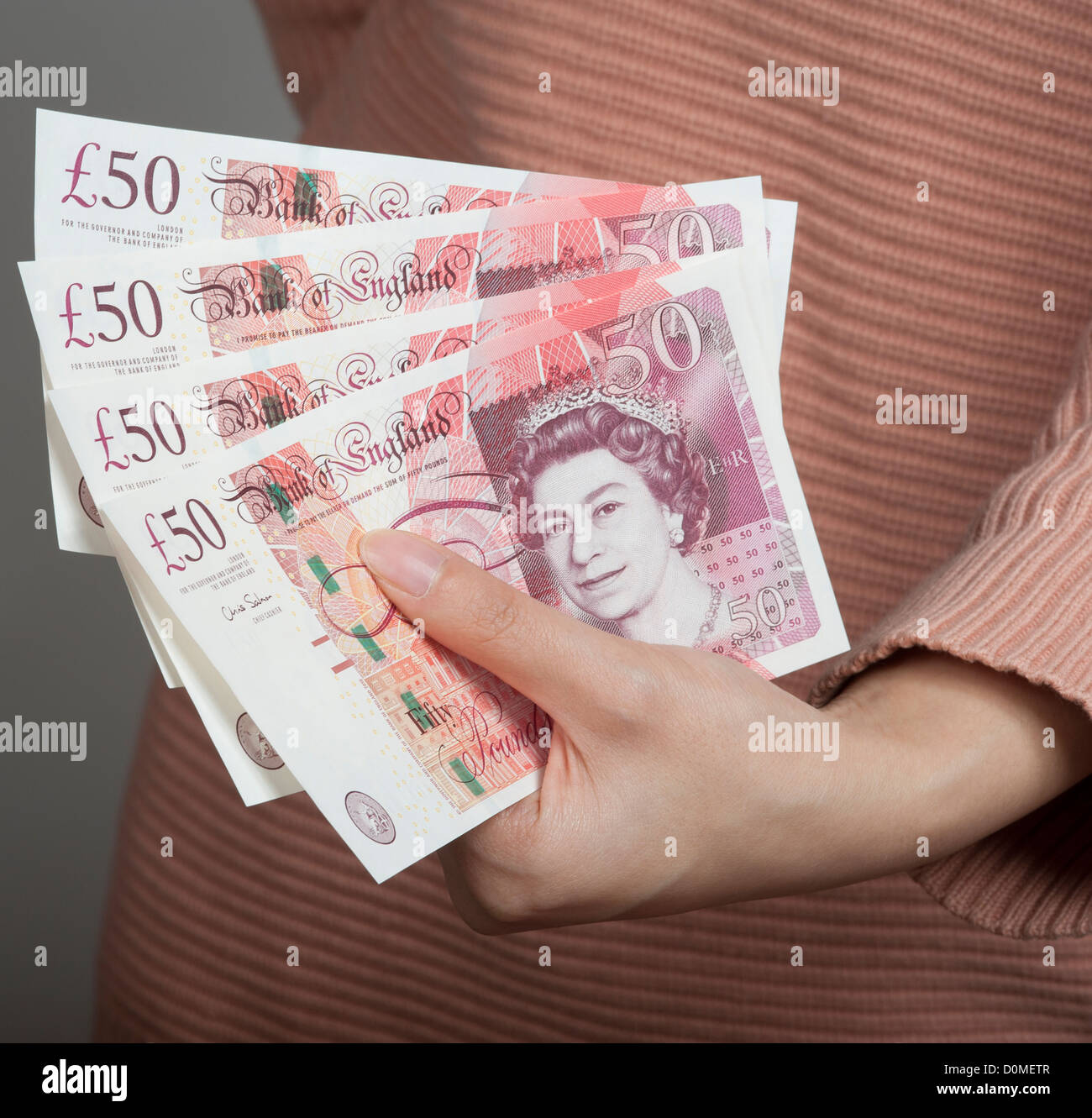 Donna di mano azienda cinquanta pound note REGNO UNITO valuta britannica Foto Stock