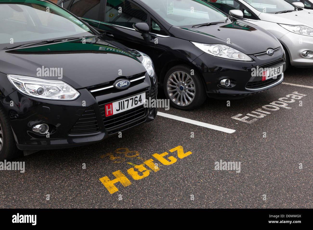 Hertz e auto Europcar in collezione area di parcheggio in aeroporto, Jersey, Isole del Canale, REGNO UNITO Foto Stock