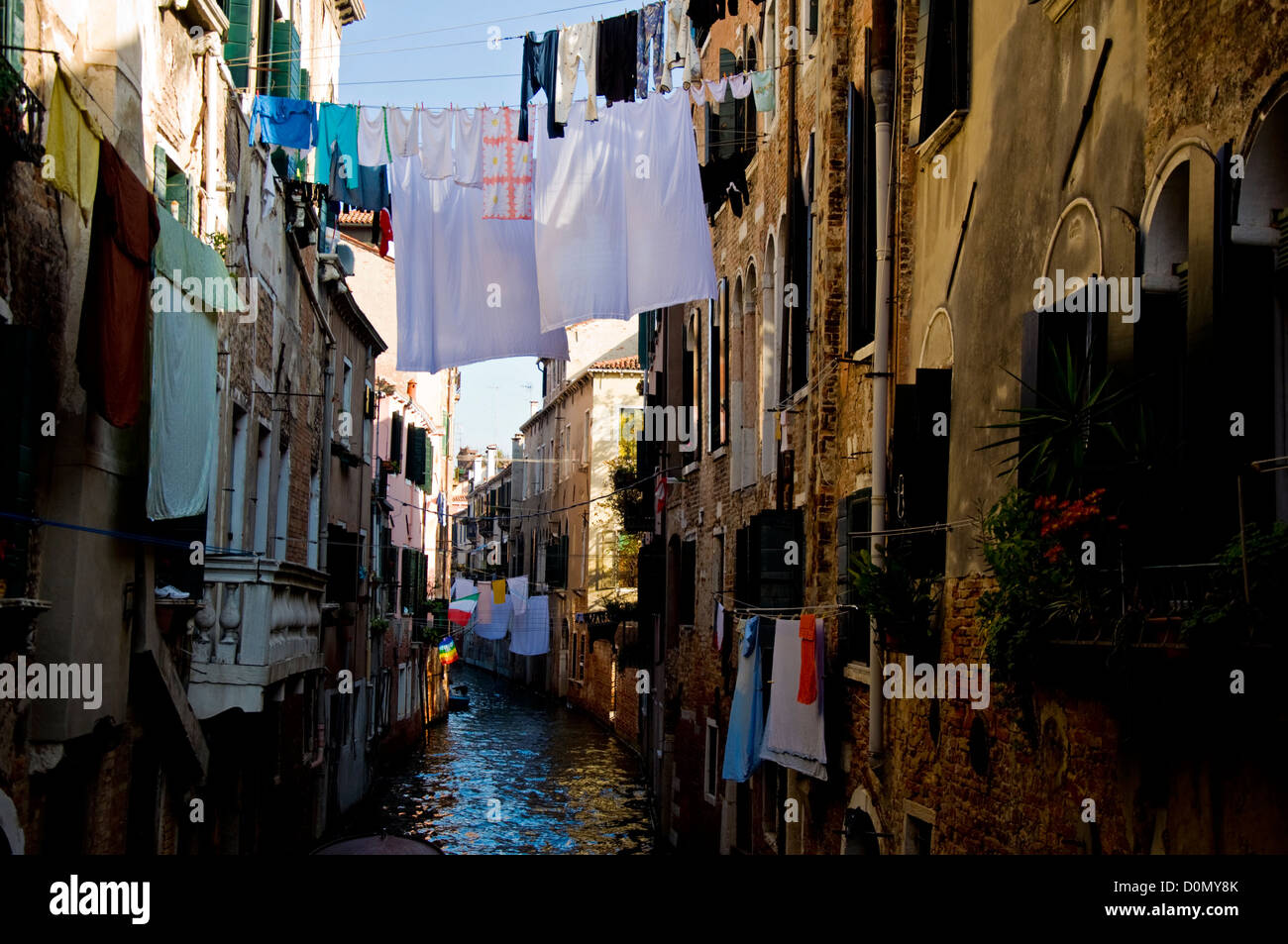 Il lavaggio appeso sulla linea estesa su canal tra appartamenti a Venezia Foto Stock