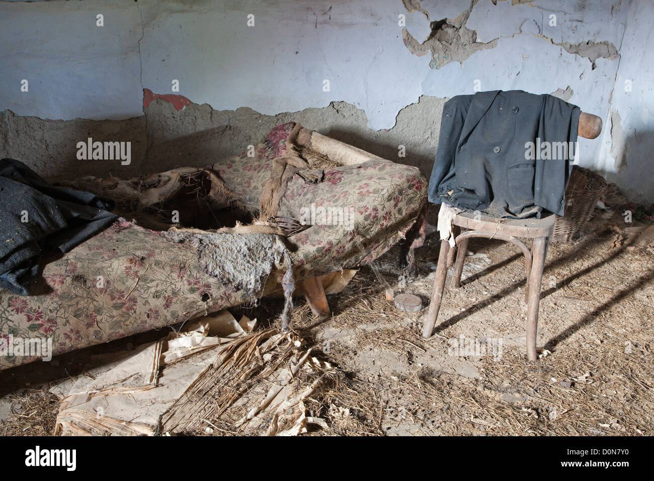 Vecchia sedia e letto in casa in rovina Foto Stock