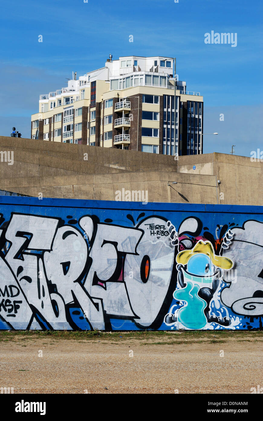 I graffiti sulla parete vicino Marina con il blocco di appartamenti essendo ridipinto in background. Brighton. East Sussex. Inghilterra Foto Stock
