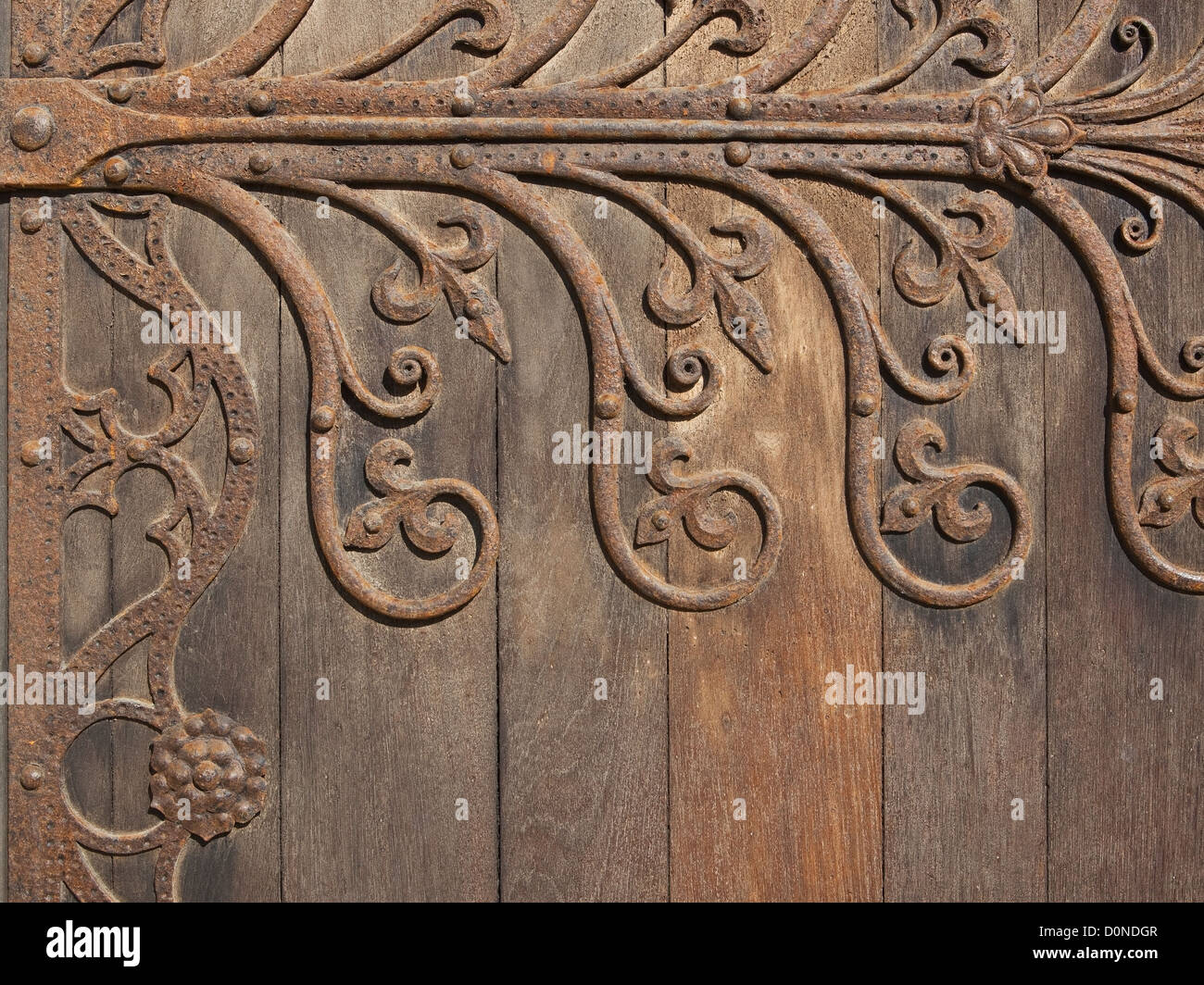 Medievale decorativo di elementi in ferro battuto montato su una vecchia porta di legno Foto Stock