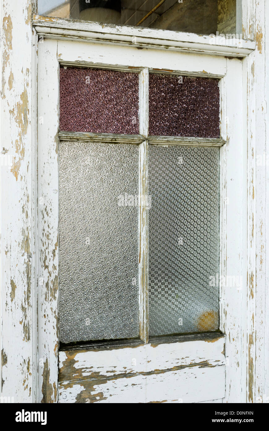 In prossimità di una finestra in una casa abbandonata con colorati e vetri smerigliati, Galles. Foto Stock