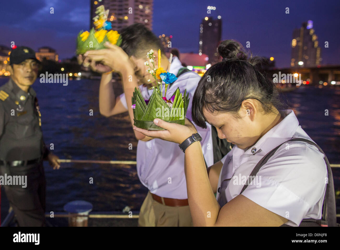 Nov. 28, 2012 - Bangkok, Thailandia - scuola bambini pregare prima di lanciare il loro krathongs su Loy Krathong al Wat Yannawa in Bangkok. Loy Krathong ha luogo la sera della luna piena del dodicesimo mese in tailandese tradizionale calendario lunare. Nel calendario occidentale questo di solito cade nel mese di novembre. Loy significa 'flottante', mentre krathong si riferisce al solito lotus-contenitore sagomato che galleggia sull'acqua. Krathongs tradizionali sono fatti di strati del tronco di un albero di banana o uno spider lily impianto. Credito: ZUMA Press, Inc. / Alamy Live News Foto Stock