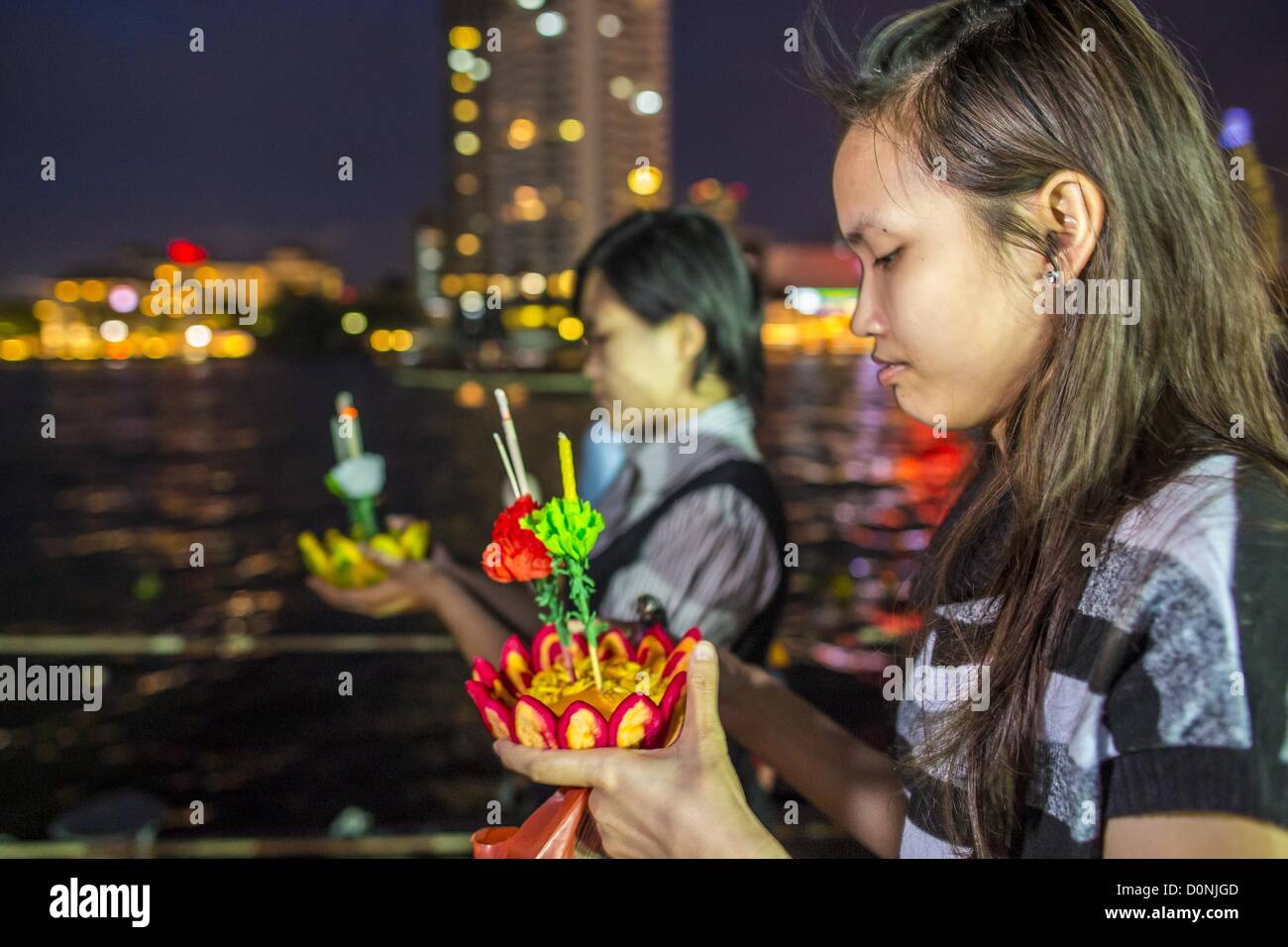 Nov. 28, 2012 - Bangkok, Thailandia - Scuola di due ragazze si preparano a lanciare i loro krathong su Loy Krathong al Wat Yannawa in Bangkok. Loy Krathong ha luogo la sera della luna piena del dodicesimo mese in tailandese tradizionale calendario lunare. Nel calendario occidentale questo di solito cade nel mese di novembre. Loy significa 'flottante', mentre krathong si riferisce al solito lotus-contenitore sagomato che galleggia sull'acqua. Krathongs tradizionali sono fatti di strati del tronco di un albero di banana o uno spider lily impianto. Credito: ZUMA Press, Inc. / Alamy Live News Foto Stock