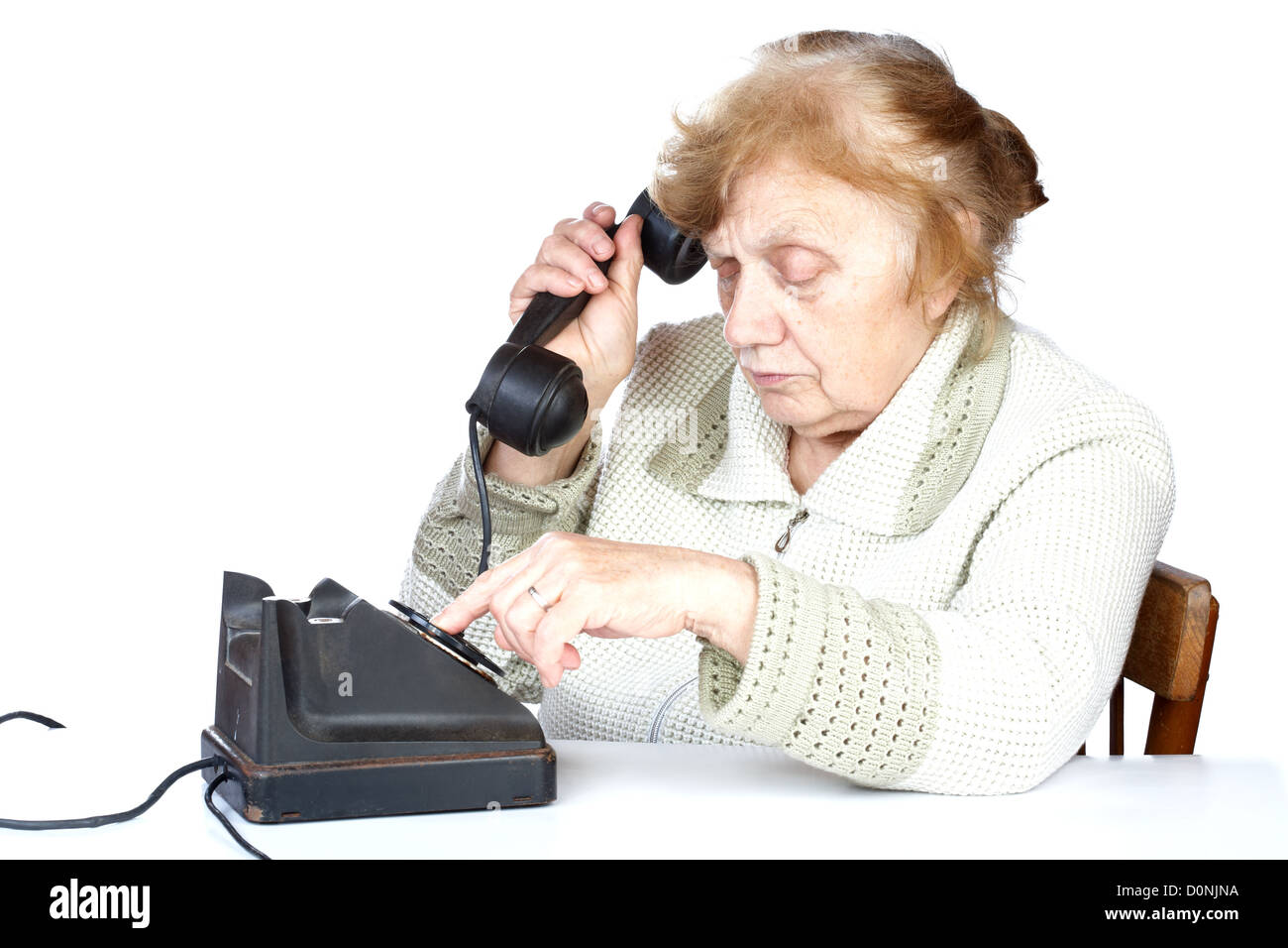 Il vecchio donna compone il numero di telefono Foto Stock