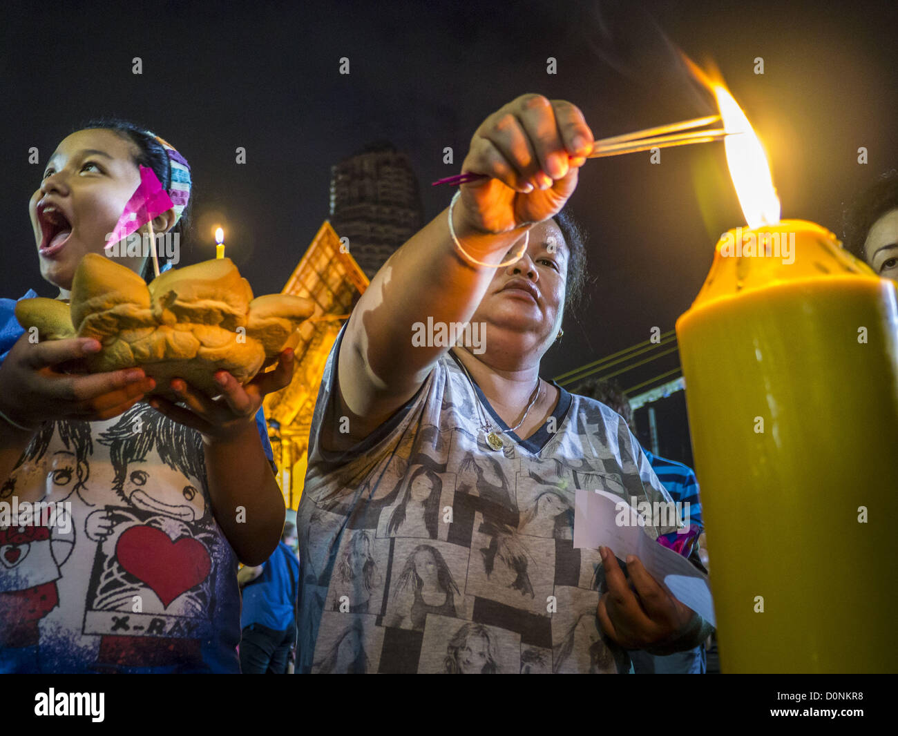 Nov. 28, 2012 - Bangkok, Thailandia - la gente la luce delle candele e incenso sui loro krathongs prima della loro immissione nel fiume Chao Phraya su Loy Krathong al Wat Yannawa in Bangkok. Loy Krathong ha luogo la sera della luna piena del dodicesimo mese in tailandese tradizionale calendario lunare. Nel calendario occidentale questo di solito cade nel mese di novembre. Loy significa 'flottante', mentre krathong si riferisce al solito lotus-contenitore sagomato che galleggia sull'acqua. Krathongs tradizionali sono fatti di strati del tronco di un albero di banana o uno spider lily impianto. Credito: ZUMA Press, Inc. / Alamy Live ne Foto Stock