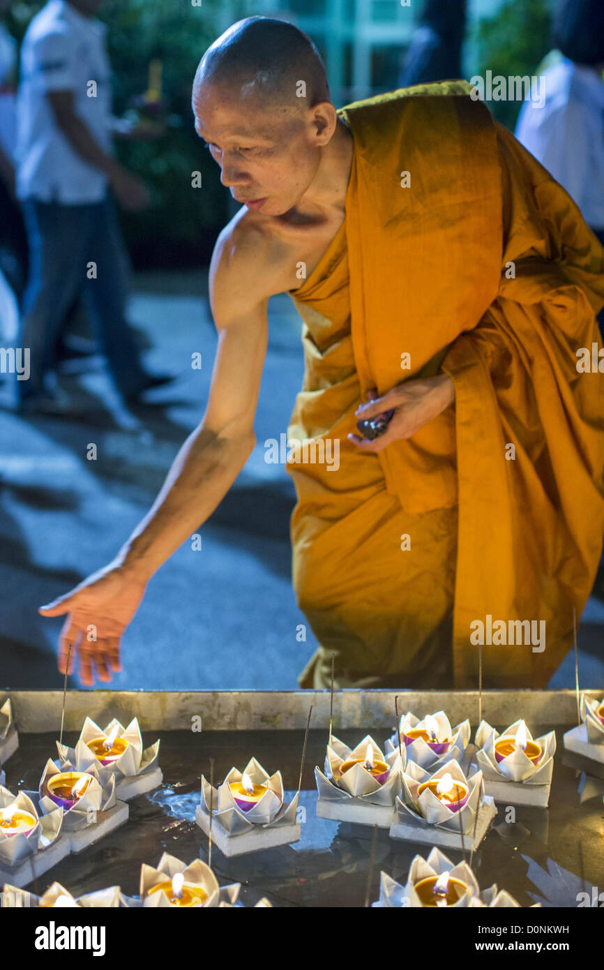 Nov. 28, 2012 - Bangkok, Tailandia - un monaco buddista pulisce un pool di krathongs su Loy Krathong al Wat Yannawa in Bangkok. Loy Krathong ha luogo la sera della luna piena del dodicesimo mese in tailandese tradizionale calendario lunare. Nel calendario occidentale questo di solito cade nel mese di novembre. Loy significa 'flottante', mentre krathong si riferisce al solito lotus-contenitore sagomato che galleggia sull'acqua. Krathongs tradizionali sono fatti di strati del tronco di un albero di banana o uno spider lily impianto. Oggi molte persone utilizzano krathongs di pasta di pane cotto al forno che si disintegra nell'acqua e nutrire i pesci. Un Foto Stock