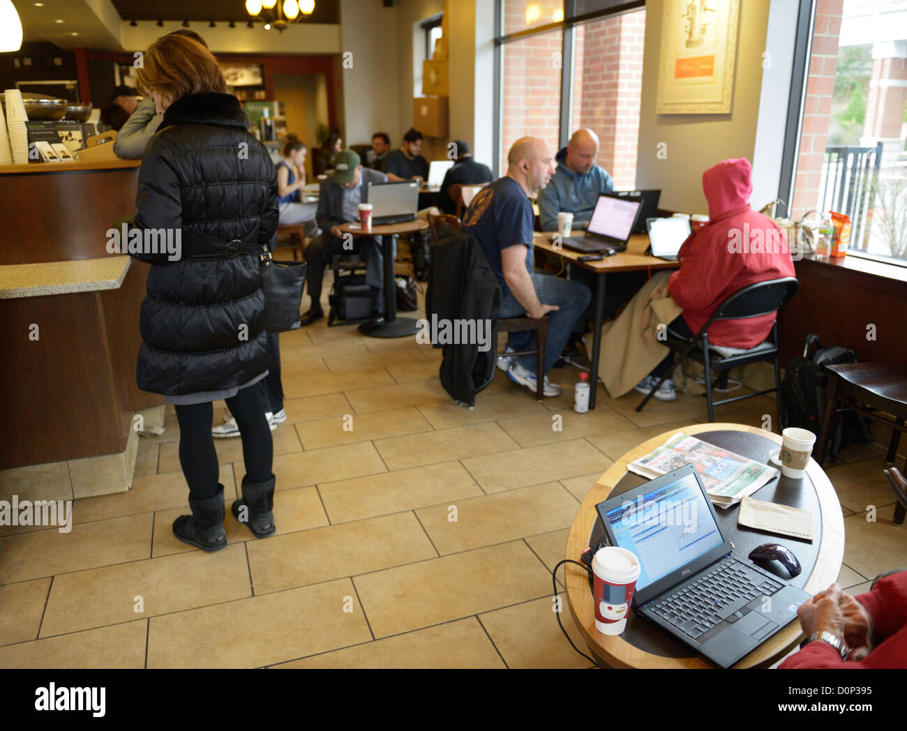 Persone che utilizzano computer portatili e di bere il caffè in uno Starbucks Foto Stock