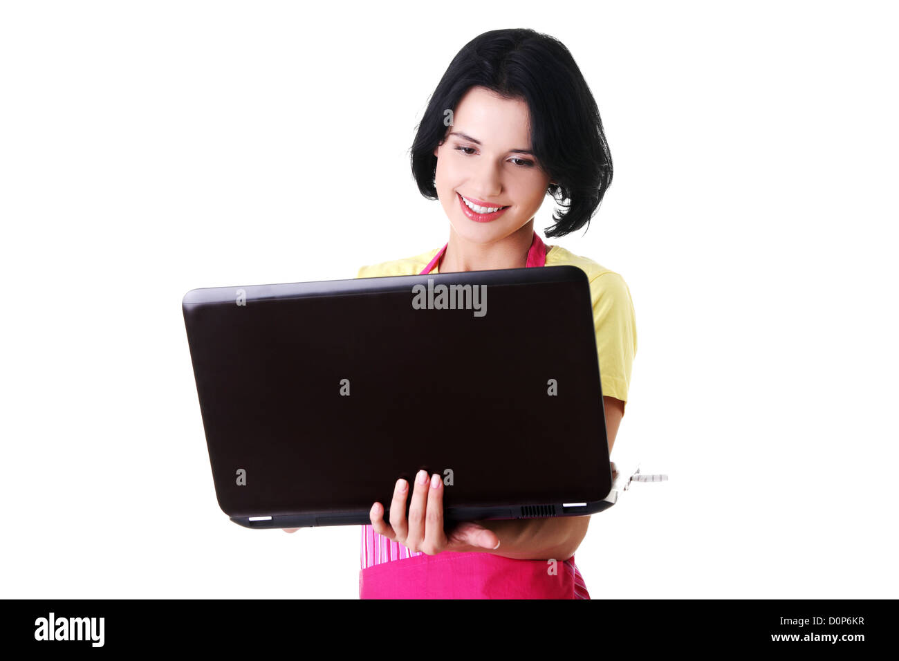 La casalinga moderna o lavoratore di sesso femminile che con laptop indossando grembiule rosa Foto Stock