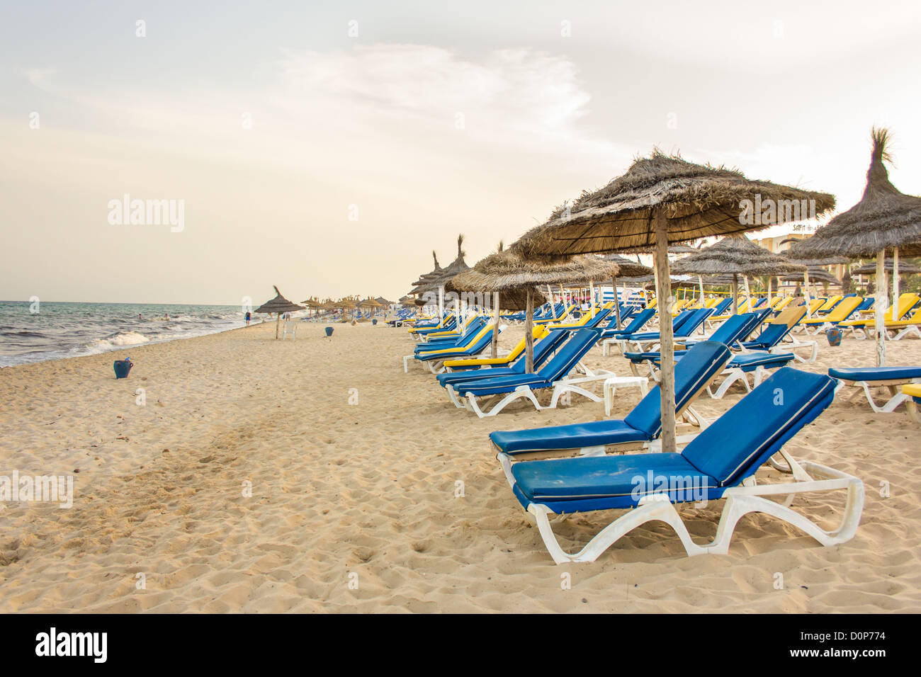 Hammamet Beach con sfumature di paglia, blue beach sedie e bella sabbia bianca lungo la costa del mar Mediterraneo Foto Stock