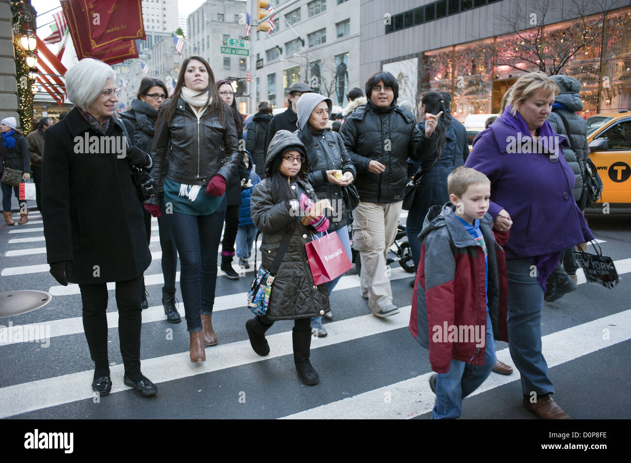 Le persone che attraversano le est 52nd Street come essi camminare lungo la Quinta Avenue a Manhattan durante il fine settimana del Ringraziamento vacanza, 2012. Foto Stock