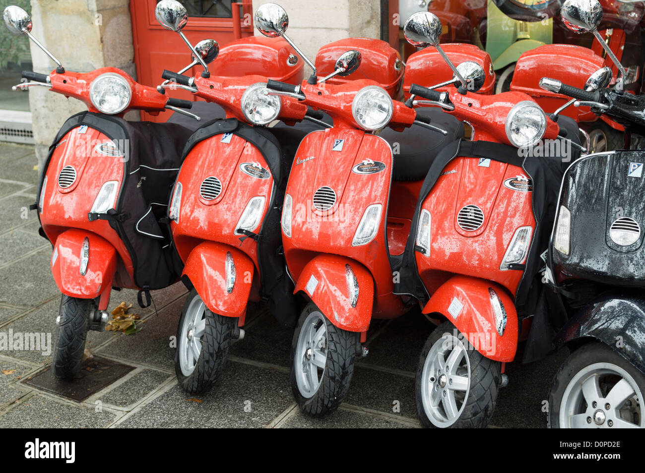 Parigi, Francia: Rosso Piaggio Vespa scooters per noleggio - parcheggiata in una riga al di fuori di un negozio di noleggio. Foto Stock