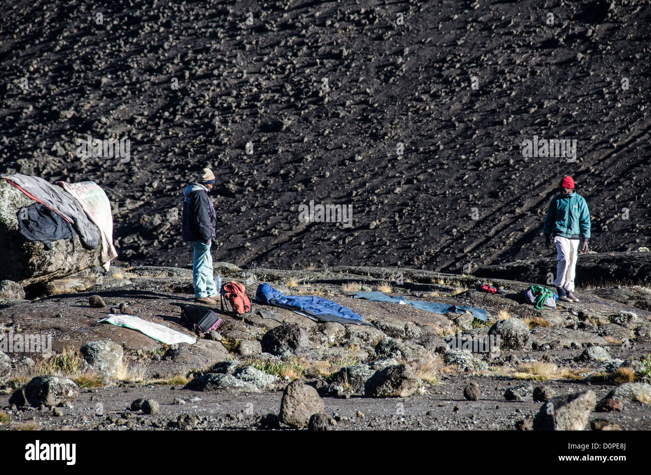 MONTE KILIMANJARO, Tanzania: Due facchini stenderanno i vestiti e i sacchi a pelo al Moir Hut Camp per cercare di asciugarli alla luce del sole prima di dover partire per la salita di quel giorno sul percorso Lemosho del monte Kilimanjaro. Foto Stock