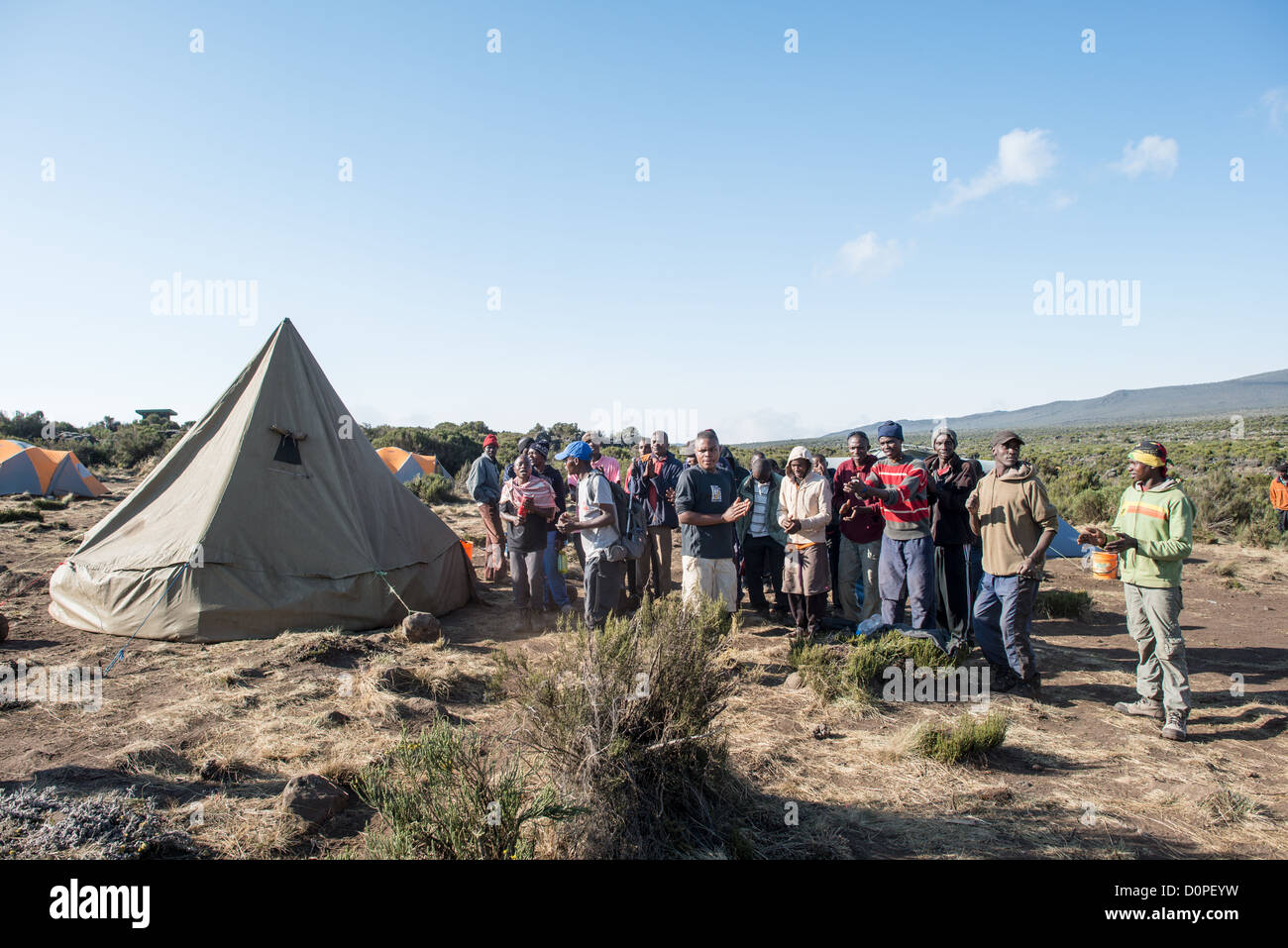 MT KILIMANJARO, Tanzania - Facchini formano un partito accogliente per i loro clienti a Shira 1 camp sul Monte Kilimanjaro. Foto Stock