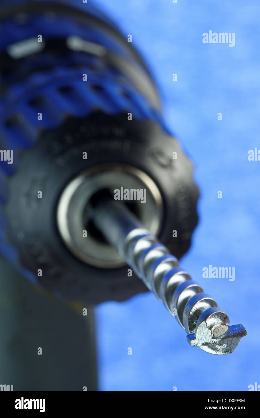 Trapano elettrico e il bit in close-up con profondità di campo ridotta. 36 mp immagine contro il blu. Loghi rimosso Foto Stock
