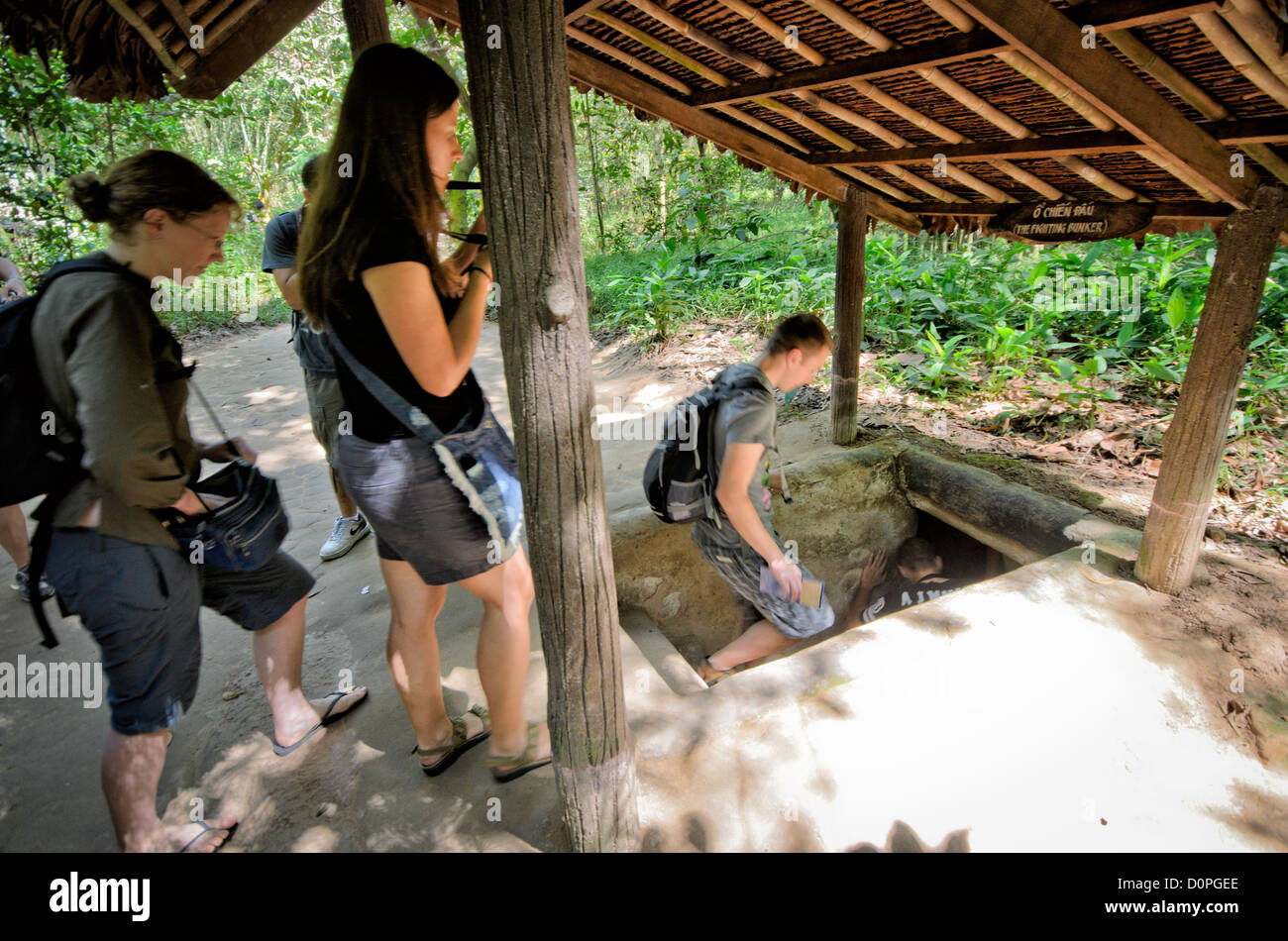 La città di HO CHI MINH, Vietnam - i turisti a piedi giù per le gallerie sotterranee. I Tunnel di Cu Chi, a nord-ovest di Ho Chi Minh City, erano parte di un più grande galleria sotterranea di rete utilizzato dal Viet Cong nella guerra del Vietnam. Parte dell'originale sistema di tunnel è stata conservata come un attrazione turistica dove i visitatori possono andare verso il basso nello stretto tunnel e vedere presenta sulle precauzioni per la difesa e la vita quotidiana dei vietnamiti che visse e combattute. Foto Stock