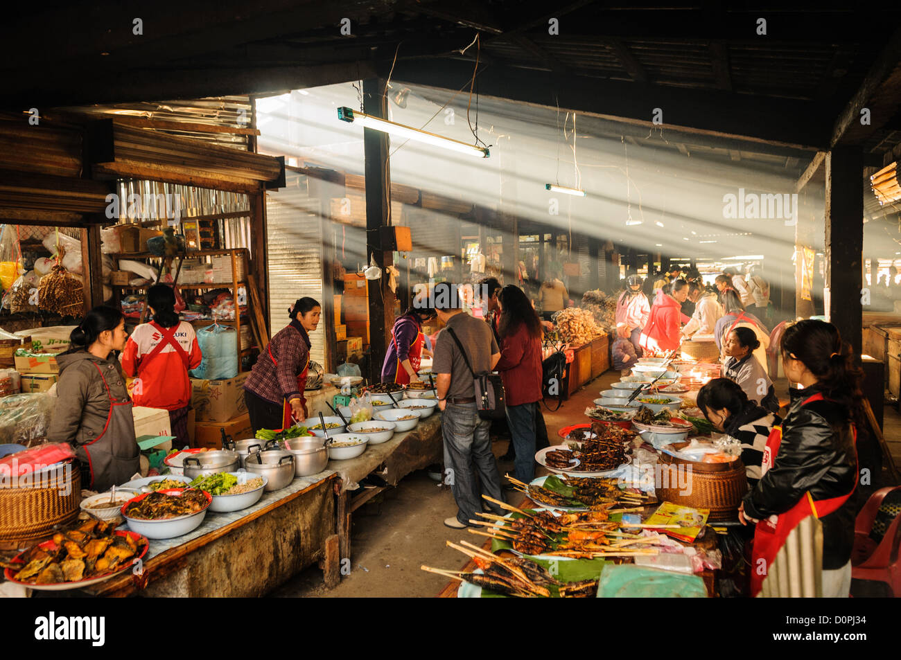 PHONSAVAN, Laos — i venditori al mercato mattutino di Phonsavan vendono un'ampia gamma di alimenti appena cucinati, tra cui passero alla griglia, maiale, pollo, insetti, e cane. Foto Stock