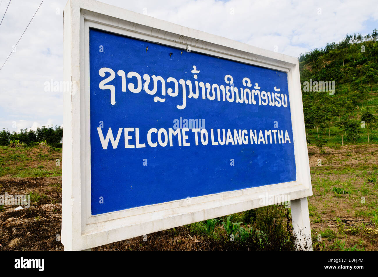 Benvenuto a Luang Namtha Sign Luang Namtha Laos // LUANG NAMTHA, Laos — Un cartello "Benvenuti a Luang Namtha" segna il confine provinciale nel Laos settentrionale. La provincia di Luang Namtha funge da regione d'ingresso nel Laos nord-occidentale, confinante sia con la Cina che con il Myanmar. La provincia è conosciuta per le sue diverse comunità etniche e funge da centro per le attività eco-turistiche della regione. La città di Luang Namtha funge da capitale provinciale e centro amministrativo. La provincia fa parte della regione del Triangolo d'Oro e svolge un ruolo significativo nel commercio transfrontaliero e negli scambi culturali. Il Laos settentrionale è cha Foto Stock