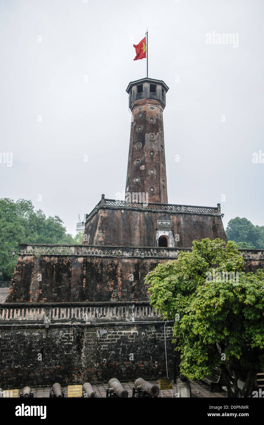 Torre della bandiera di Hanoi Museo di storia militare del Vietnam Hanoi Vietnam // HANOI, Vietnam - la storica Torre della bandiera di Hanoi, costruita tra il 1805 e il 1812, si erge a 33,5 metri di altezza presso il Museo di storia militare del Vietnam. La torre presenta una scala a chiocciola di 54 gradini che conduce ad una sala di osservazione e ha sventolato la bandiera nazionale vietnamita ininterrottamente dal 10 ottobre 1954. Questa reliquia storica e culturale nazionale è sia un simbolo dell'indipendenza vietnamita sia un punto di riferimento centrale del complesso museale militare. La struttura ottagonale rappresenta uno dei pochi elementi architettonici rimasti da Foto Stock