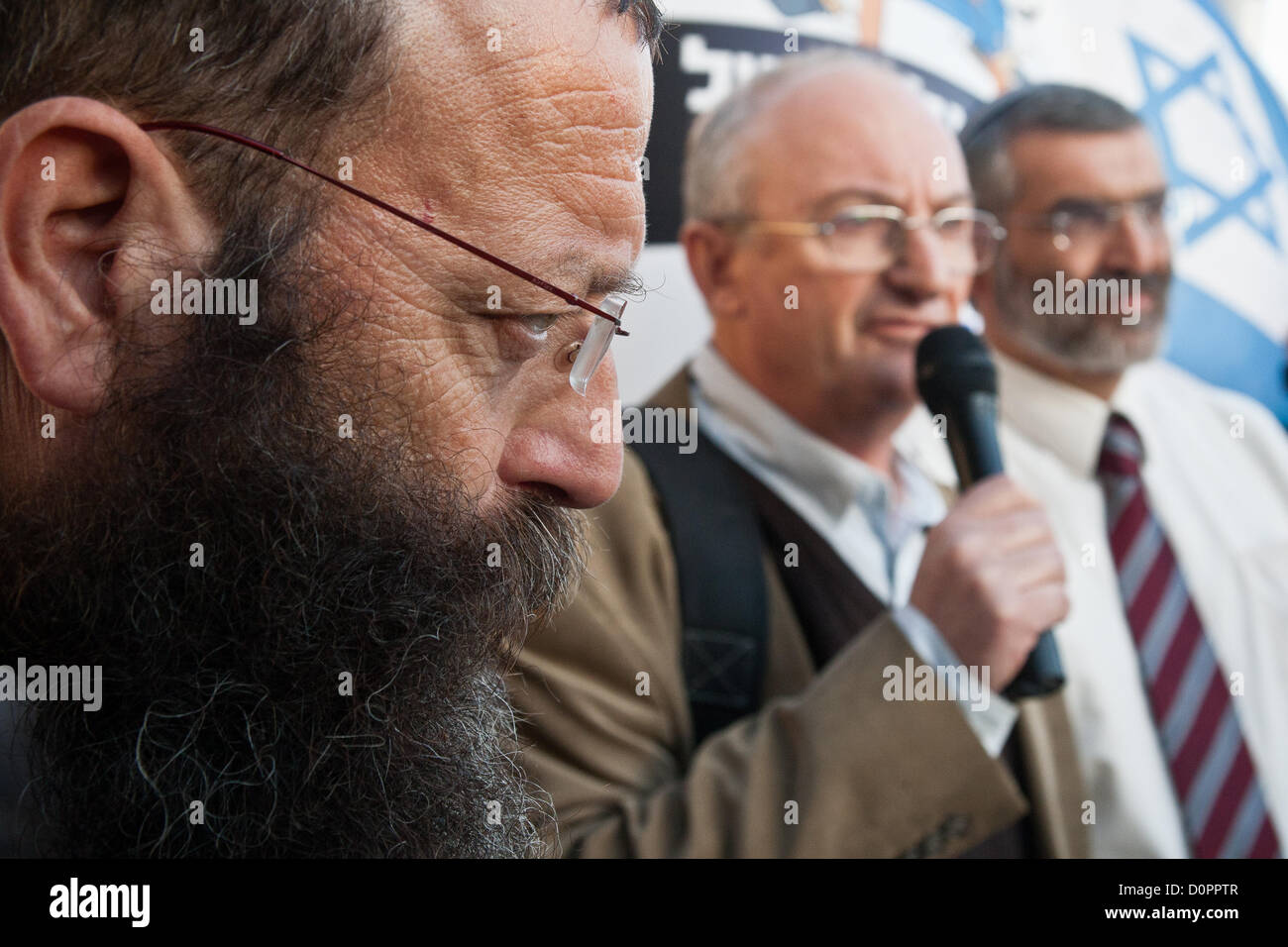 Gerusalemme, Israele. Il 29 novembre 2012. A destra dell' attivista Baruch Marzel (in primo piano a sinistra) contempla l'indirizzo da MK Aryeh Eldad (C), dell'Otzma Leyisrael partito, nella parte anteriore della sede delle Nazioni Unite a Gerusalemme. Gerusalemme, Israele. 29-Nov-2012. MKs Michael Ben-Ari e Aryeh Eldad, di estrema destra Otzma Leyisrael partito, attivisti di piombo in una bandiera palestinese tentativo di masterizzazione al palazzo delle Nazioni Unite a Gerusalemme la dimostrazione contro la costituzione dello Stato palestinese offerta all' Assemblea generale delle Nazioni Unite a New York. Foto Stock