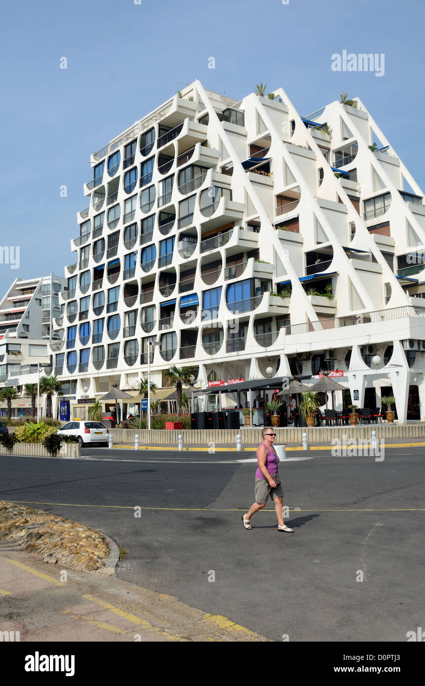 Tourist Crossing Road di fronte a le Grand Pavois (1968) o Piramide di Jean Balladur Apartment Building la Grande-Motte Resort Town Hérault Francia Foto Stock