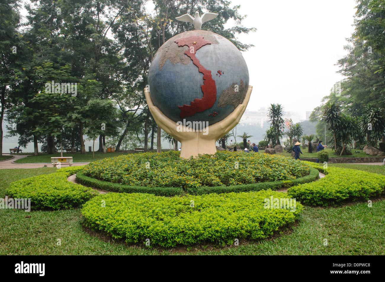 HANOI, Vietnam - una scultura artistica di un globo con le mani e una colomba sulla riva del lago Hoan Kiem ad Hanoi, Vietnam. La scultura è intitolata "Hope & Love for Peace". Foto Stock