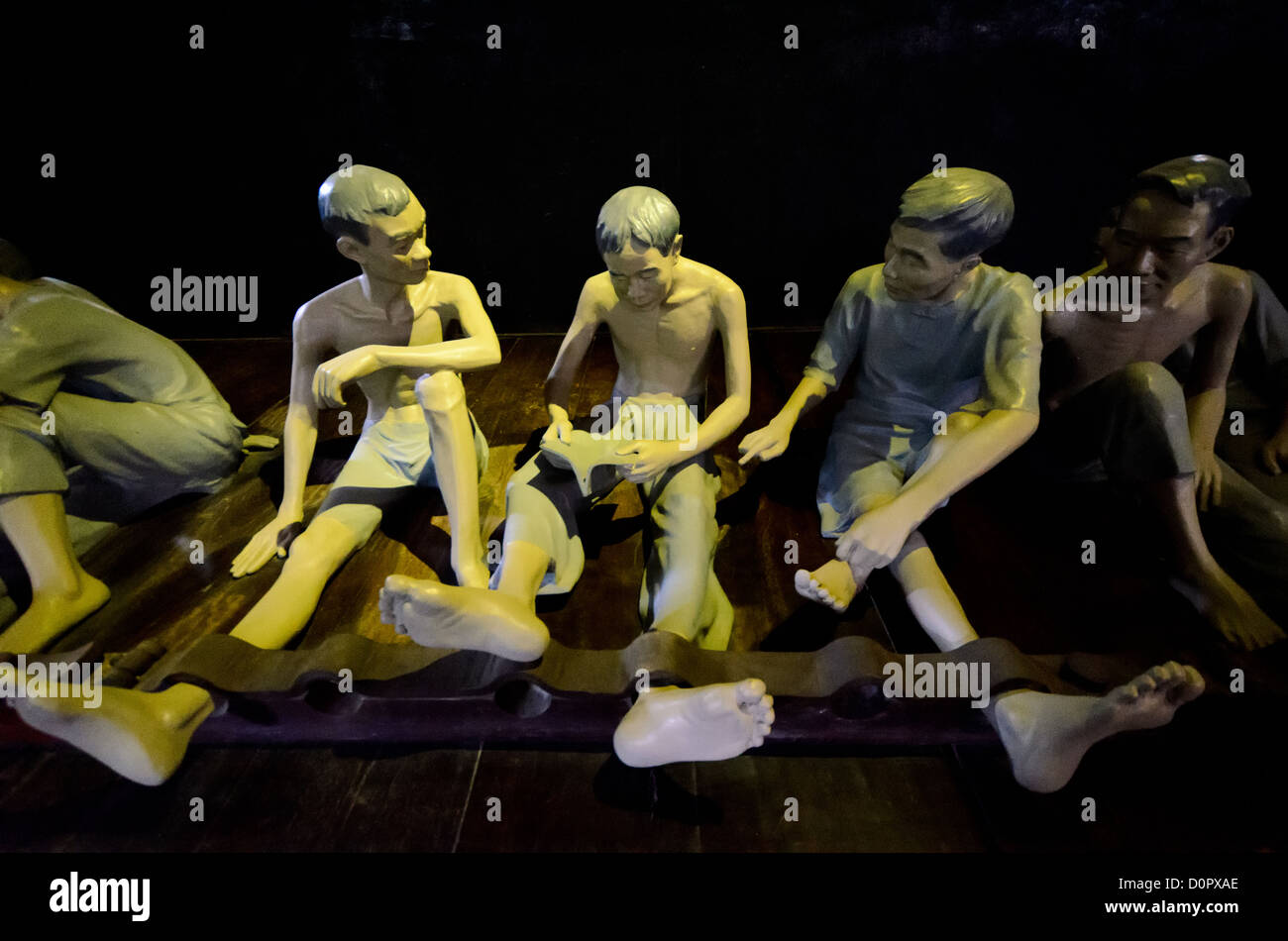 Hoa lo Prison detenuto Sculpture Hanoi Vietnam // HANOI, Vietnam — dettaglio di alcune delle sculture che illeludono le condizioni in cui i detenuti sono stati tenuti nella prigione di Hoa lo, con una gamba stretta per impedire il movimento. La prigione di THoa lo, nota sarcasticamente come Hanoi Hilton durante la guerra del Vietnam, era originariamente una prigione coloniale francese per prigionieri politici e poi una prigione nordvietnamita per prigionieri di guerra. È particolarmente famosa per essere la prigione utilizzata per i piloti americani abbattuti durante la guerra del Vietnam. Foto Stock