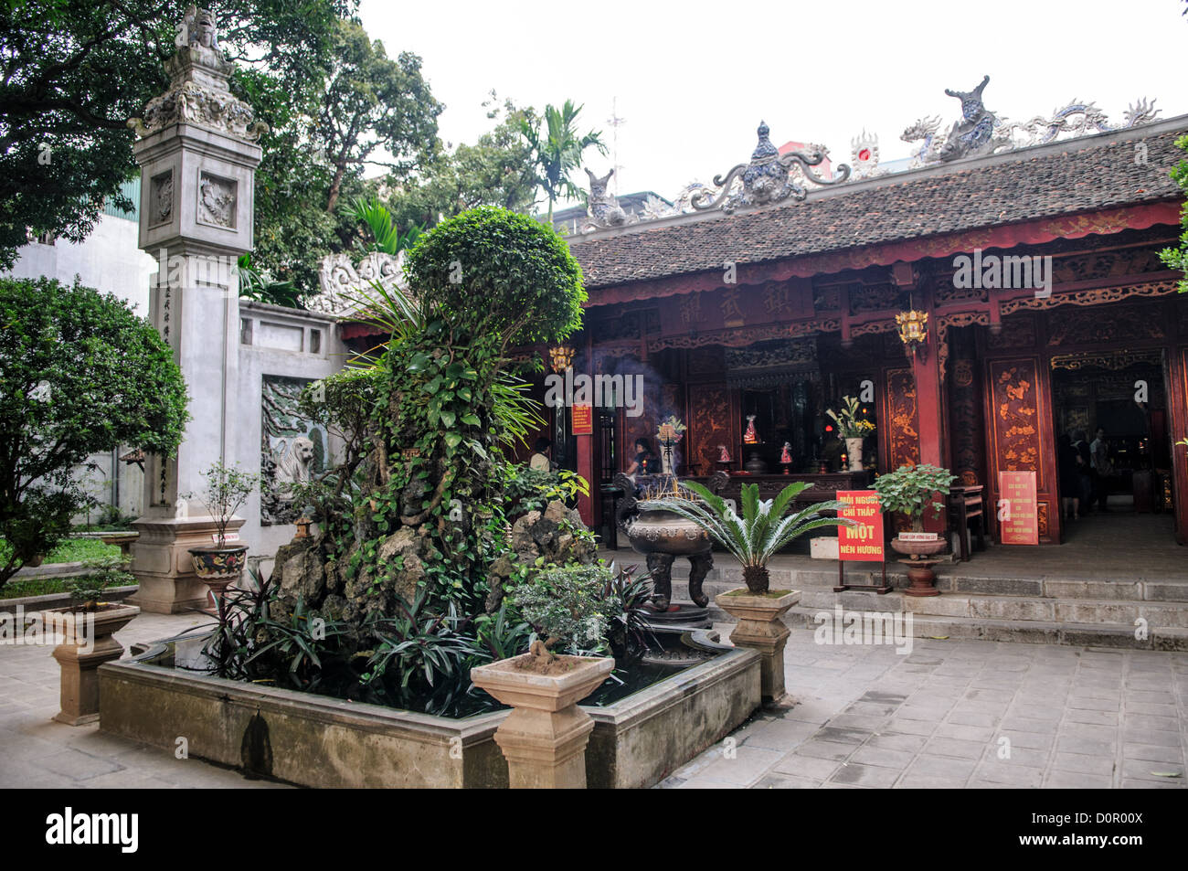 Tran Quoc Pagoda Courtyard Hanoi Vietnam // HANOI, Vietnam - il cortile della Pagoda Tran Quoc offre uno spazio di ritrovo all'interno del complesso del tempio sull'isolotto Golden Fish del Lago Ovest. Originariamente istituito nel vi secolo e trasferito nel 1615, il cortile del tempio conserva elementi architettonici buddisti tradizionali vietnamiti. Lo spazio serve sia funzioni cerimoniali che comunali all'interno di uno dei templi buddisti più antichi del Vietnam. Foto Stock