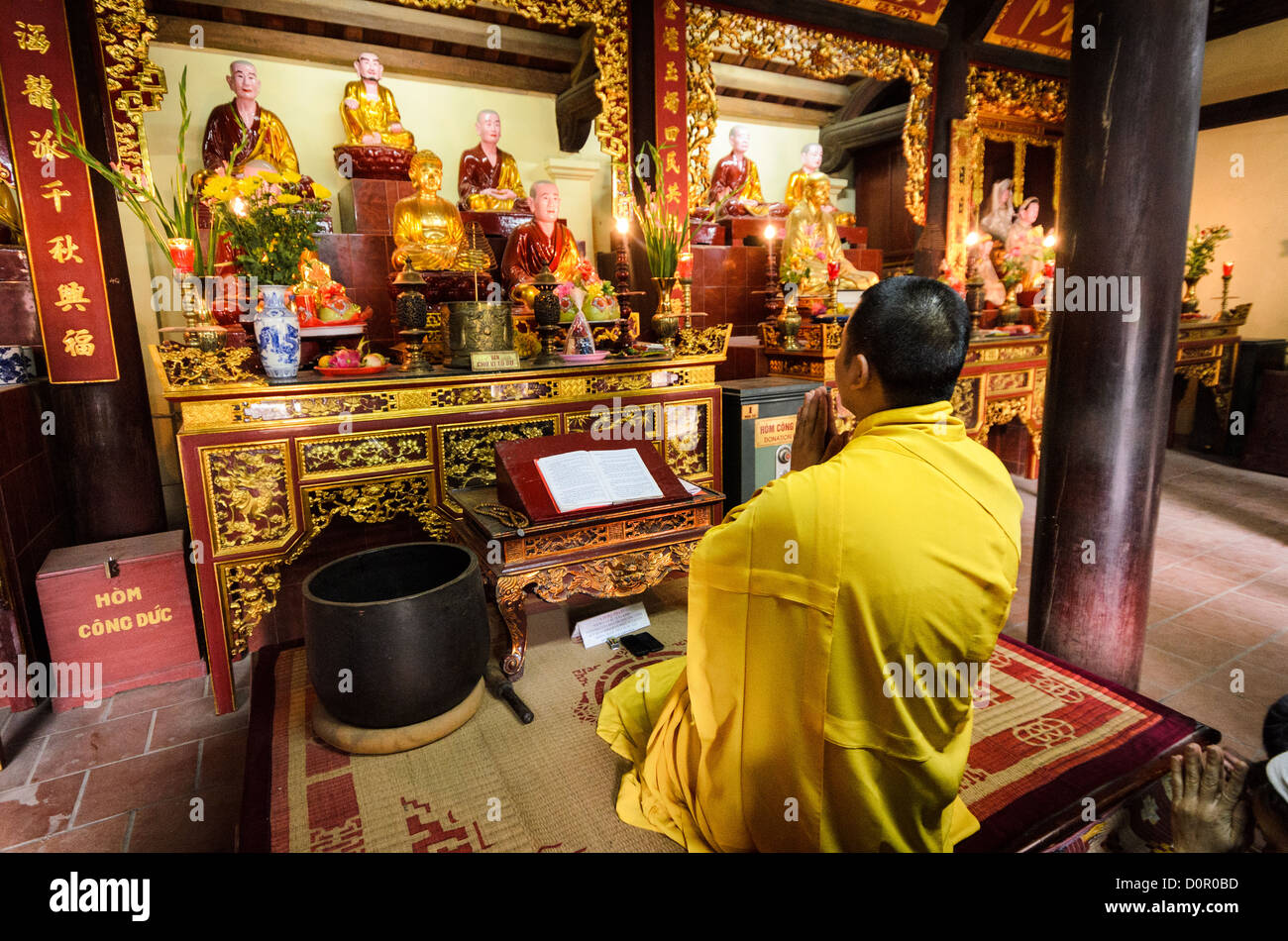 HANOI, Vietnam - un monaco buddista prega all altare a Tran Quoc Pagoda su una piccola isola sul Lago Ovest (Ho Tay). Originariamente costruito nel VI secolo sulle rive del Fiume Rosso, un cambiamento di rotta del fiume costretto la Pagoda ad essere riposizionato nel 1615 per il Pesce Dorato (Kim Ngu) isolotto sul lago. Foto Stock