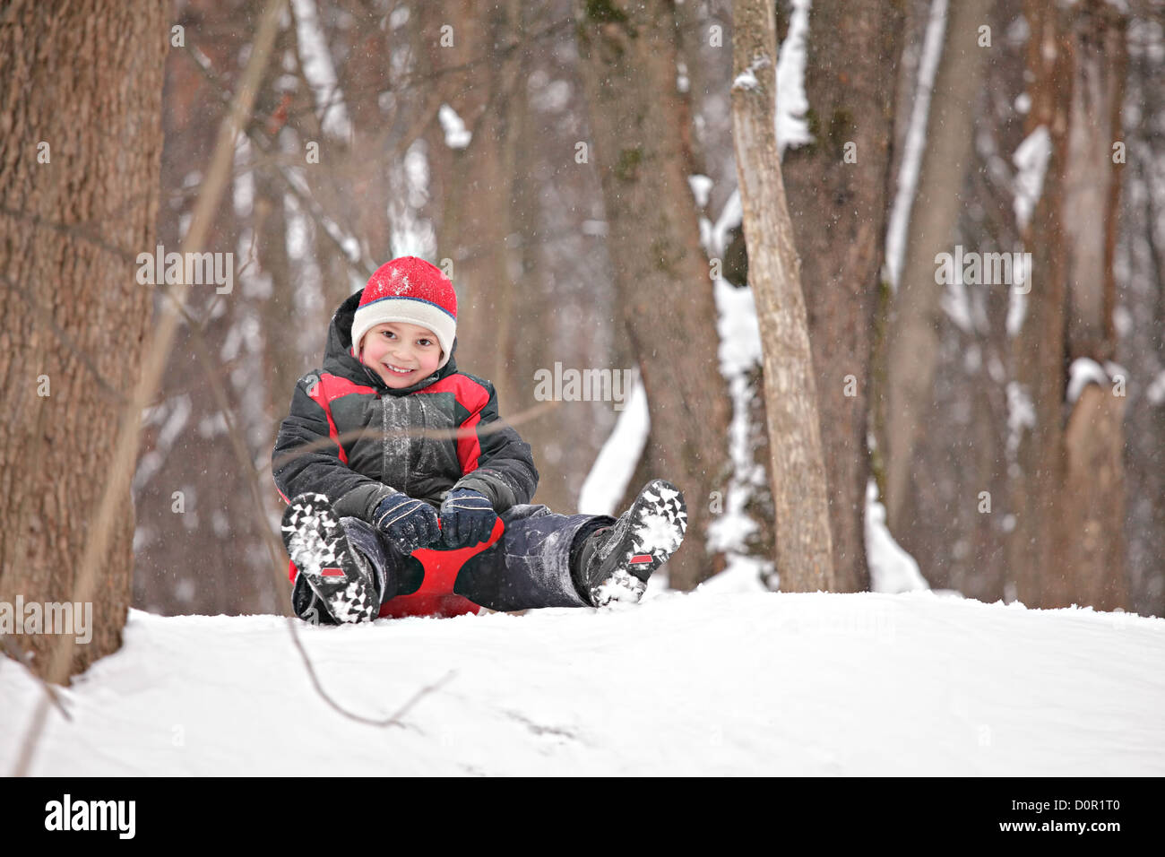 Kid su tobbogan sulla sommità di una collina Foto Stock
