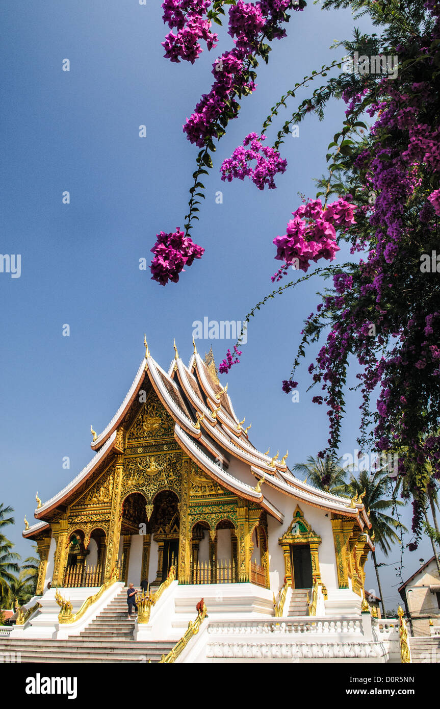 LUANG PRABANG, Laos — la facciata ornata e la linea del tetto ripida angolata di Haw Pha Bang (Cappella del Palazzo) presso il Museo del Palazzo reale di Luang Prabang, Laos. Questa elegante struttura, iniziata nel 1963, mette in mostra elementi architettonici tradizionali del Laos con i suoi intricati dettagli e il suggestivo tetto. Foto Stock