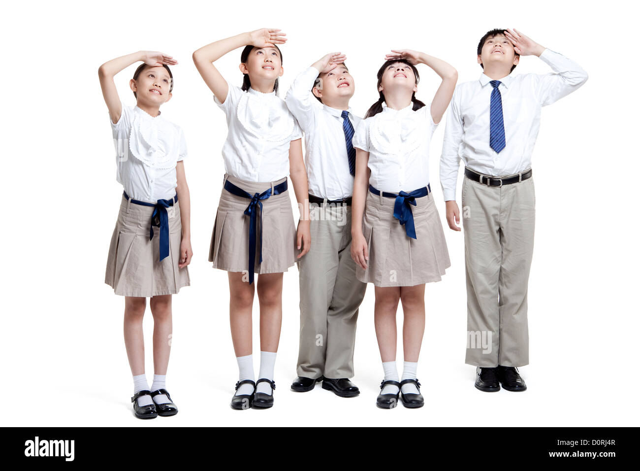 Scolari cercando con le mani gli occhi di schermatura dal sole Foto Stock