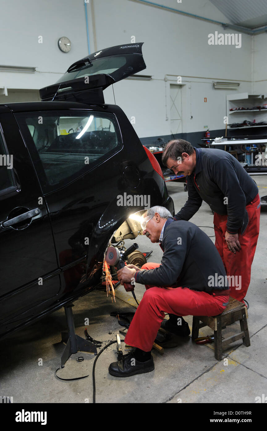Due meccanici che lavorano in garage auto Foto Stock