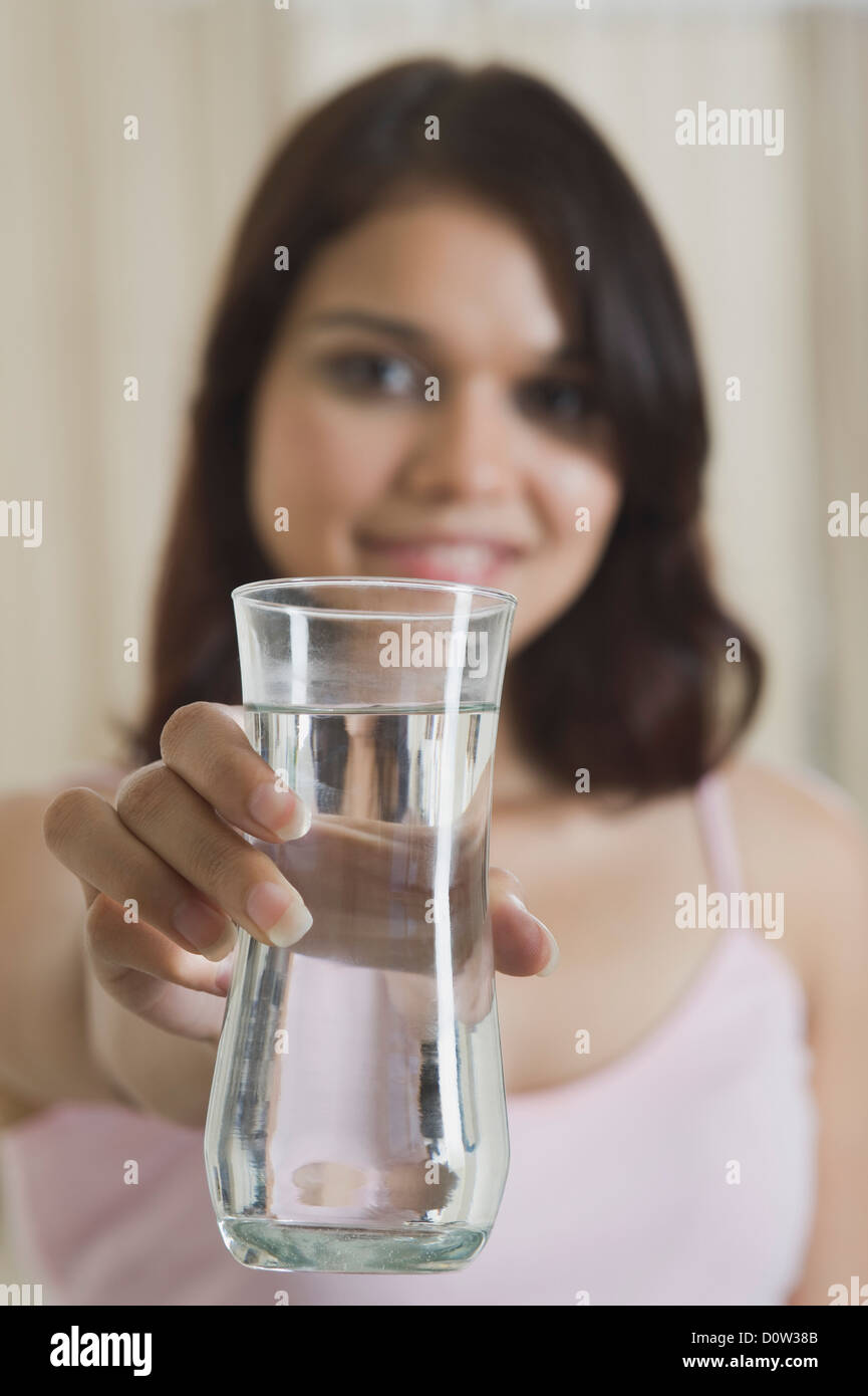 Donna che offre un bicchiere di acqua Foto Stock