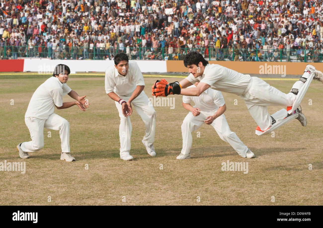 Cricket wicket keeper e fielders tenta per la cattura Foto Stock