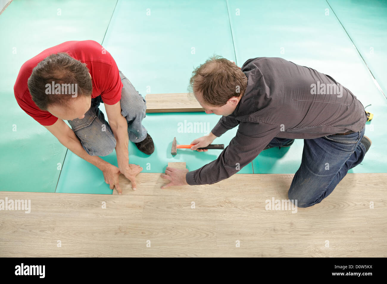 Gli uomini installazione di pavimentazione Foto Stock