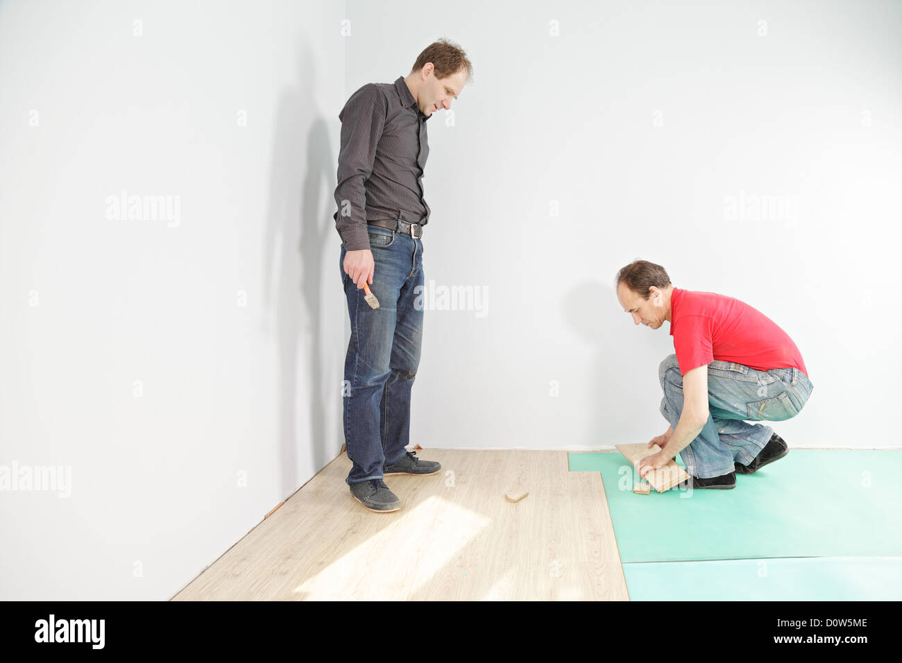 Uomo che guarda l'installazione di pavimentazione Foto Stock
