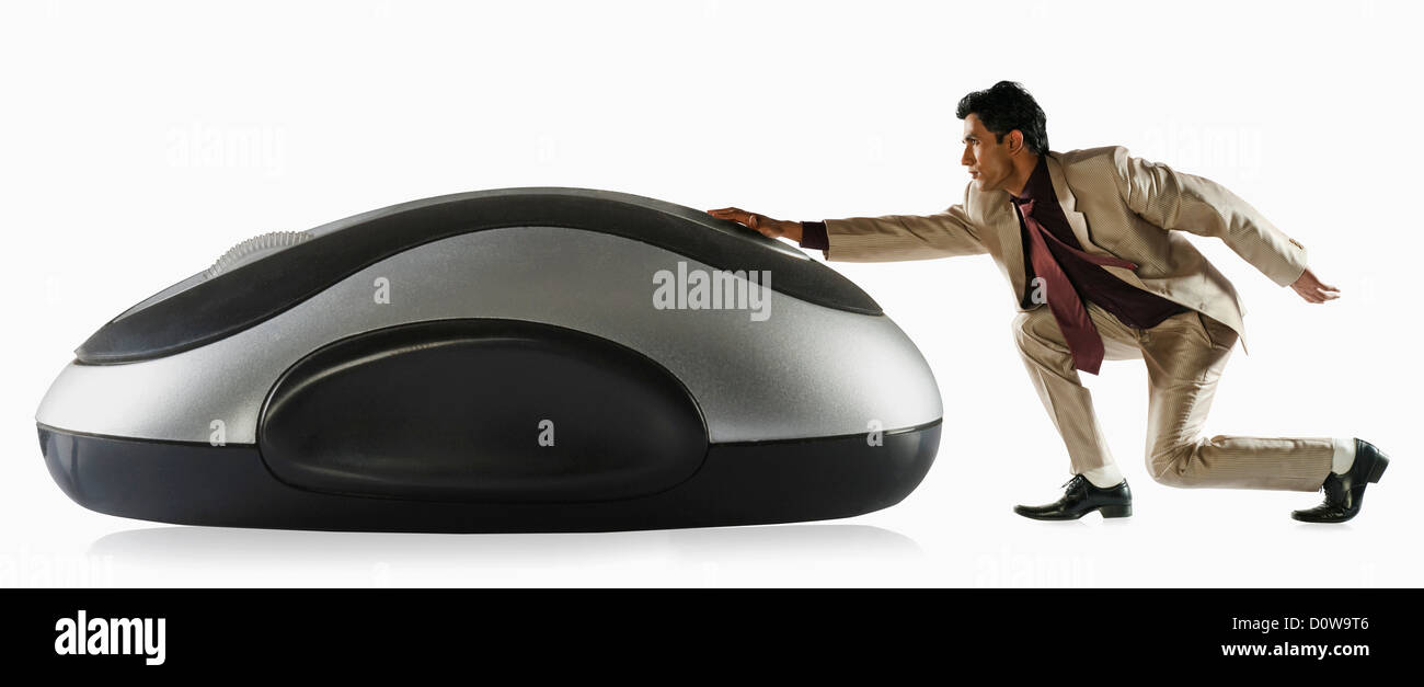 Imprenditore operando un sovradimensionato il mouse del computer Foto Stock