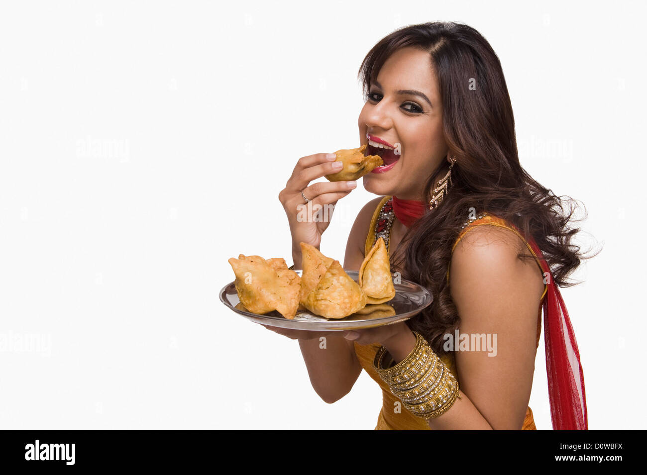 Donna di mangiare samosa il tradizionale spuntino indiano Foto Stock