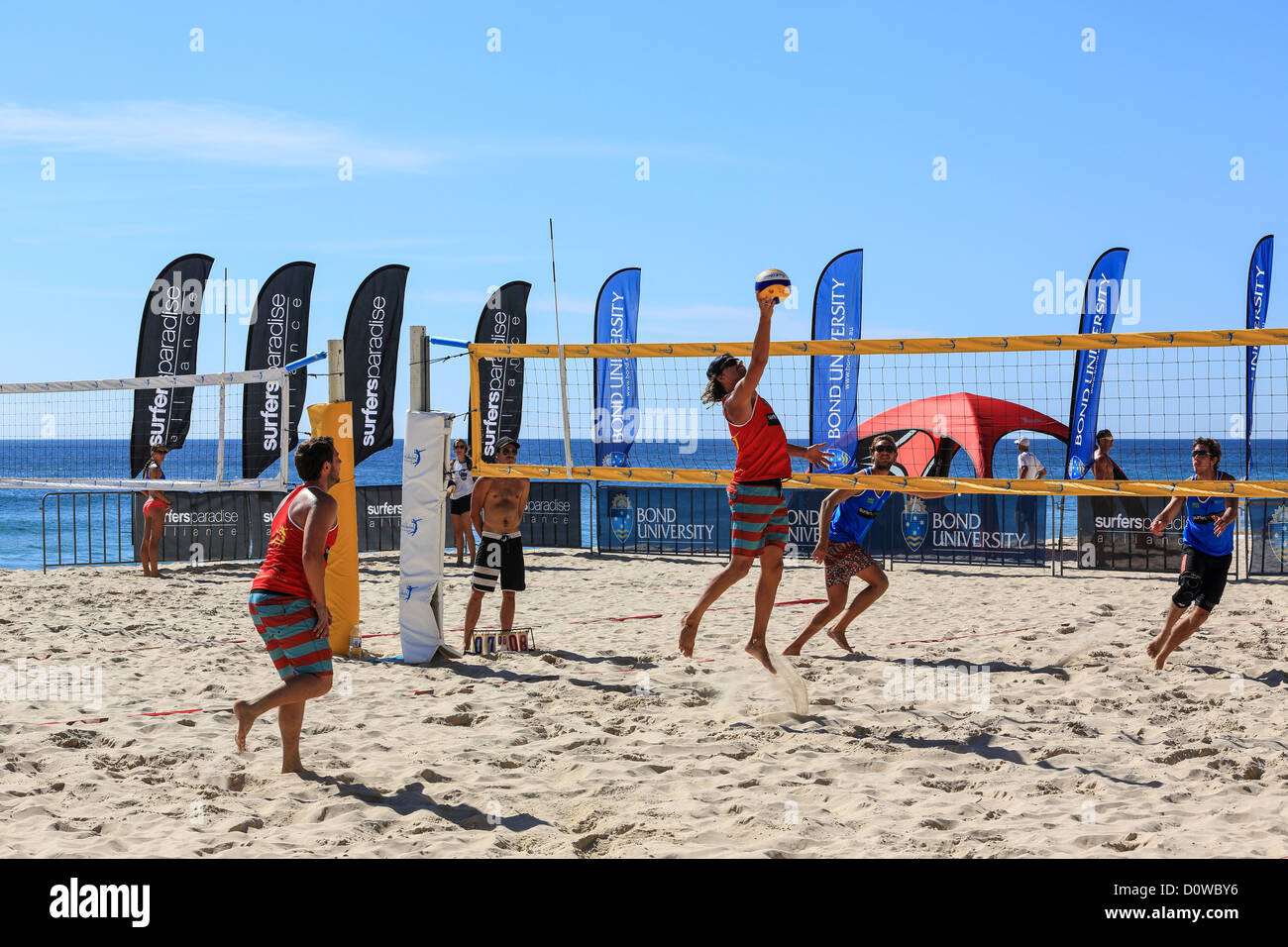 Mens team gioca a beach volley a Surfers Paradise il primo giorno di una mattina d'estate Foto Stock