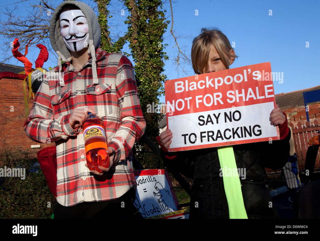 Uomo che indossa anonimo maschera facciale ; 'Guy Fawkes maschere'   manifestanti contro un REGNO UNITO 'Dash al gas' e fracking per gas di scisto, marciando per le strade di Lytham St Annes in rotta per Caudrilla del sito di perforazione Anna's Road off Case del Nord Lane, St Annes, Blackpool, Lancashire. Anti-fracking manifestanti desidera che la perforazione di stop fino a che i rischi sono completamente valutati. Foto Stock